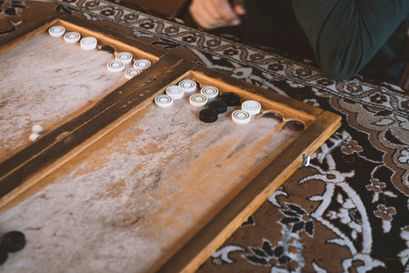 a man plays at a wooden table, backgammon