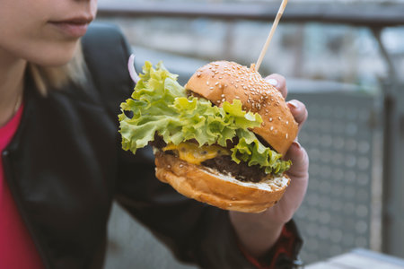woman eating burger on the street.の写真素材