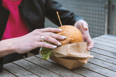 woman eating burger on the street.の写真素材