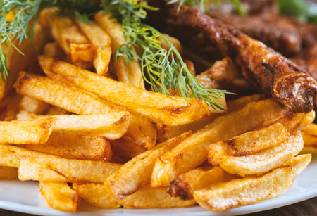 roasted chicken and french fries on a wooden tableの写真素材