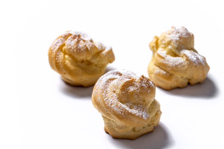 Decorating profiteroles with powdered sugar. Eclairs with icing sugarの写真素材