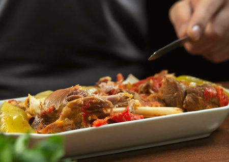 man eats lamb stew on the bone with vegetables. Khashlama is popular Armenian dish, which is...