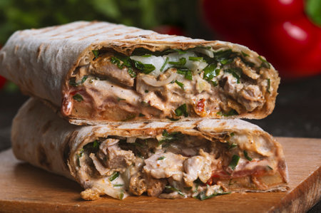 Shawarma sandwich fresh roll of, Grilled Meat and salad with white sauce on black background.