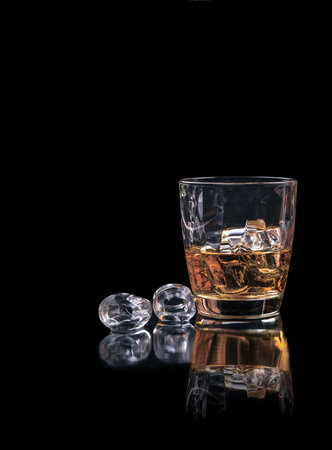 Whiskey glass with ice on black backgroundの写真素材