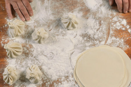 Chef cook making khinkali on wooden table. Process preparation georgian meal. food concept.の写真素材
