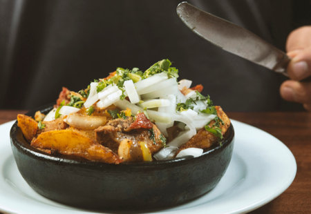Man eating Beef stew with potatoes, carrots and herbs on black background with copyの写真素材