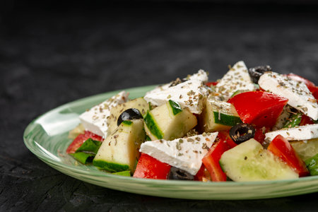 Greek salad with feta cheese, tomato, cucumber and olives on a black backgroundの写真素材