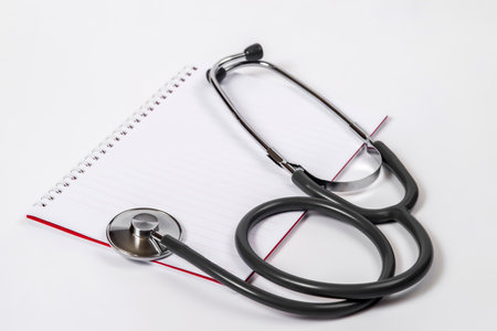 Doctor desk.Stethoscope and notebook on white backgroundの写真素材