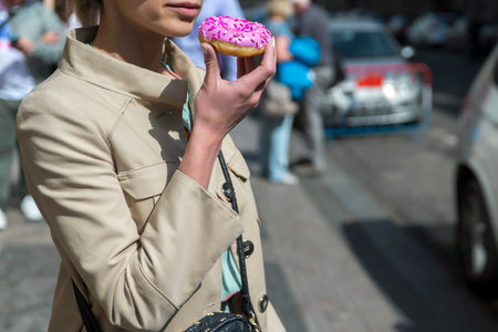Young woman with donuts in her hands on the streetの写真素材