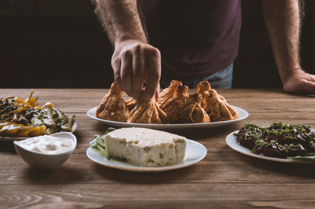 woman eat Traditional Georgian dinner, khinkali,cheese and dolma platter on wooden table.の写真素材