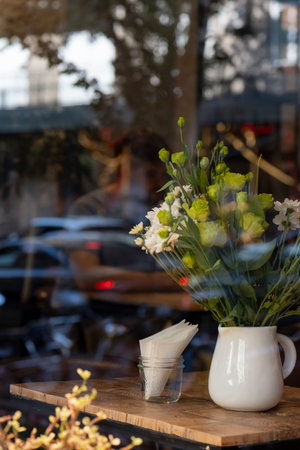 beautiful flowers in a vase shooting off through the window in a cafe
