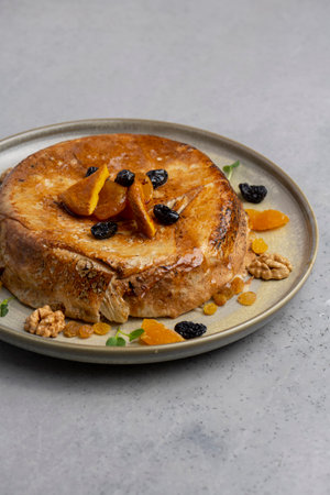 cake with dried apricots, raisins and walnuts on gray background