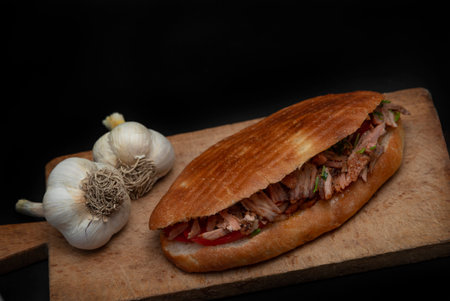Shawarma and garlic on the wooden desk on black background