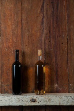 Bottle of red wine on a wooden background in a wineryの写真素材