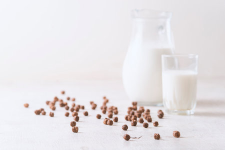 Milk in a glass and chocolate balls on a light background.の写真素材