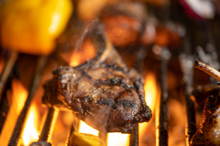 roasted meat and vegetables on the grill with flames and vegetables, close up