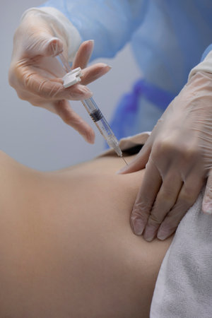 Physiotherapist doing an injection to the back of a patientの写真素材