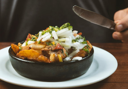 Man eating Beef stew with potatoes, carrots and herbs on black background