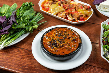Thai spicy chili sauce with pork in black bowl on wooden tableの写真素材