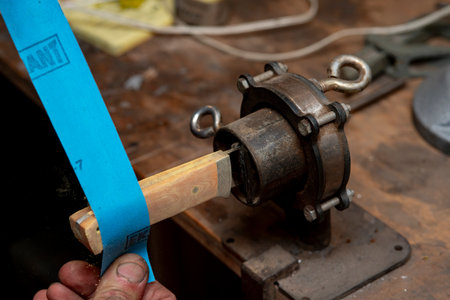 A close-up of a craftsman's hands as he creates a knife.