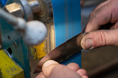 A close-up of a craftsman's hands as he creates a knife.