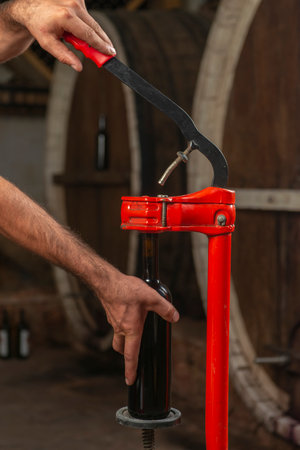 close-up of a man corking a bottle of wine at a winery