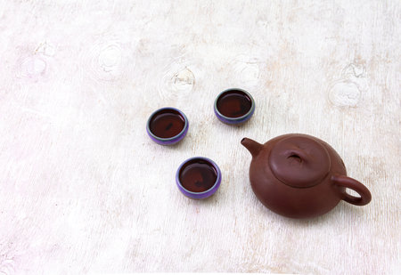 teapot and cups of black tea on a white wooden backgroundの写真素材