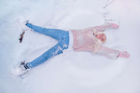 young woman making a snow angelの写真素材
