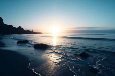 Beautiful sunset at the beach with rocks and waves in the foregroundの素材