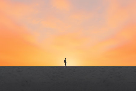 Silhouette of man standing on the concrete floor with sunset backgroundの素材