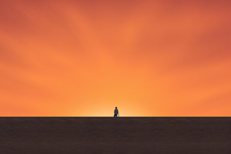 Silhouette of a man standing in the desert at sunset.の素材