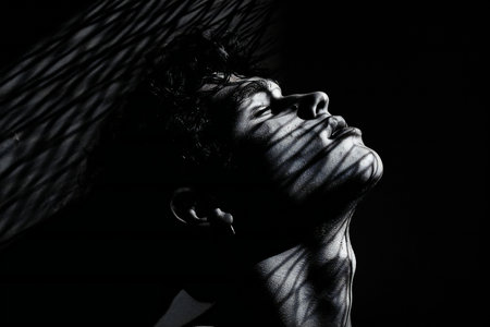 Portrait of a young man with closed eyes on a black backgroundの素材