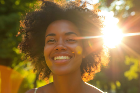 Portrait of a smiling young african american woman with afro hairstyle outdoorsの素材