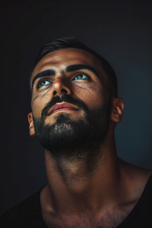Portrait of a handsome young man with beard and mustache looking upの素材