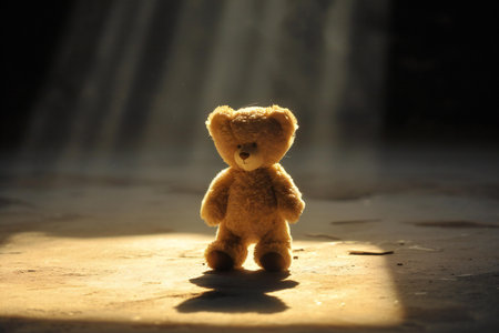 Teddy bear in the rays of light on a dark background.の素材