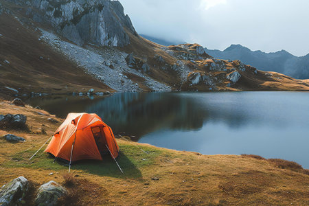 Orange tent on a mountain lake in the Carpathian mountains.の素材