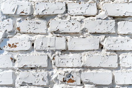 White brick wall with peeling paint. Abstract background for design.の素材