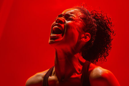 Portrait of a beautiful young african american woman in red lightの素材