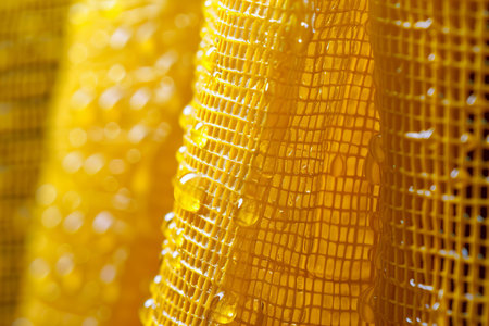 Close up of yellow fabric with water droplets. Abstract background.