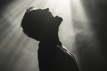 Silhouette of a man in a dark room with rays of light