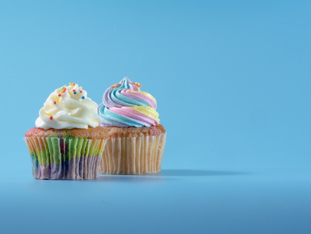 Colorful and enteresting cupcake isolated on blue background studio close up shot.の写真素材