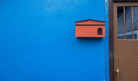 Background Red mail box on the blue wall concreteの写真素材