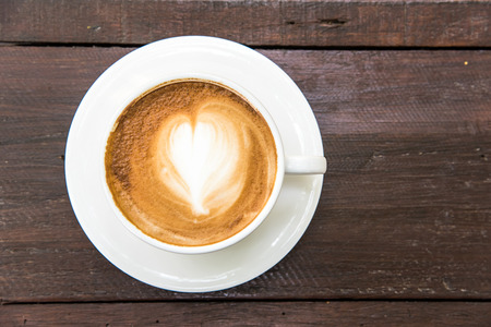 heart pattern latte art coffee, white coffee cup on the wooden table