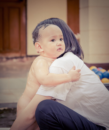 Asian mother soothe baby to stop crying Mother hug baby infront of huosemother protect baby from scarryingの写真素材