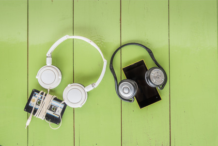 Concept of different technology between Smartphone cassette tape and headphone all were on the wood boardの写真素材