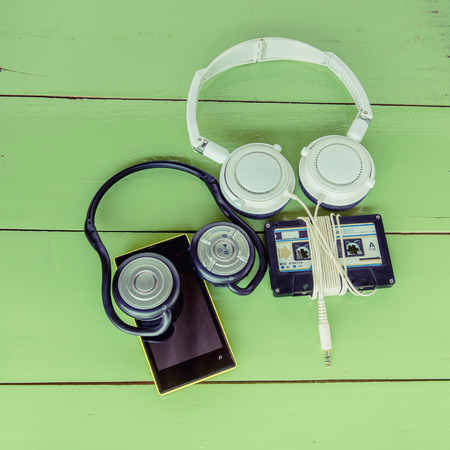 Smartphone cassette tape and headphone on the wood boardの写真素材