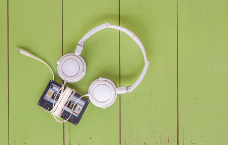 Cassette tape and head phone on green color wood boardの写真素材