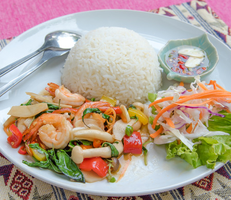 Stir-fried shrimp with holy basil and rice set serve with fish sauce mixed with red chili and lime . (Thai food name is \"PAD KRAPAO\" )の写真素材
