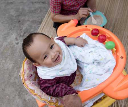 Baby eating food by mother feeding, family scene of Thailandの写真素材