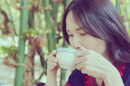 Thai lady in mountain people dress drinking coffeeの写真素材